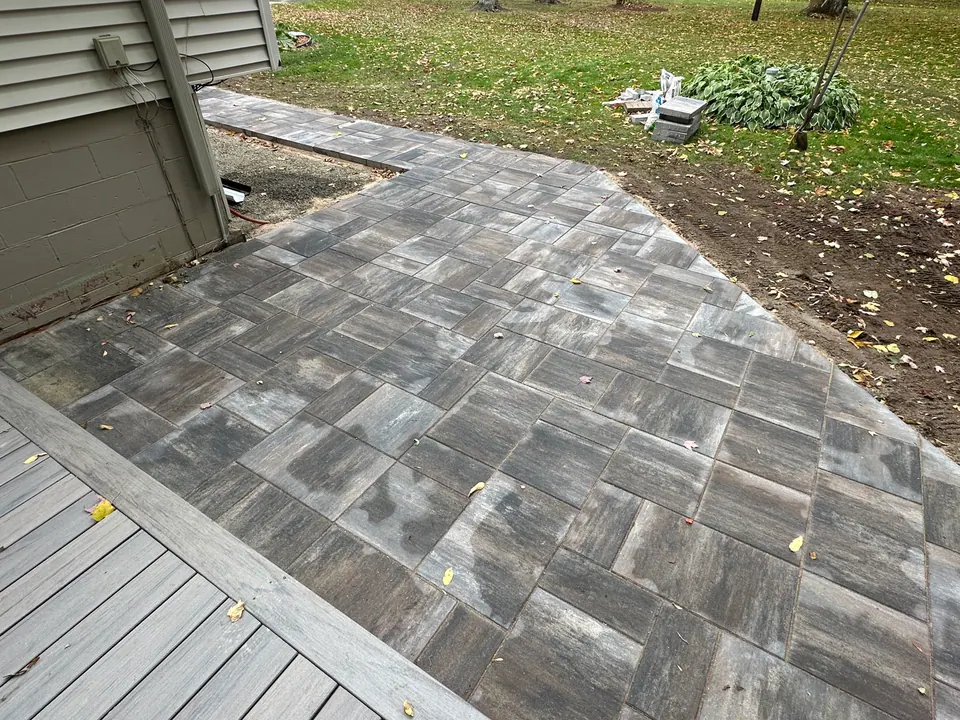 Grey paver walkway leading from a new deck