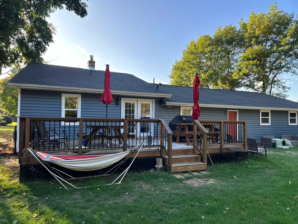Backyard deck with railing on a blue-sided home