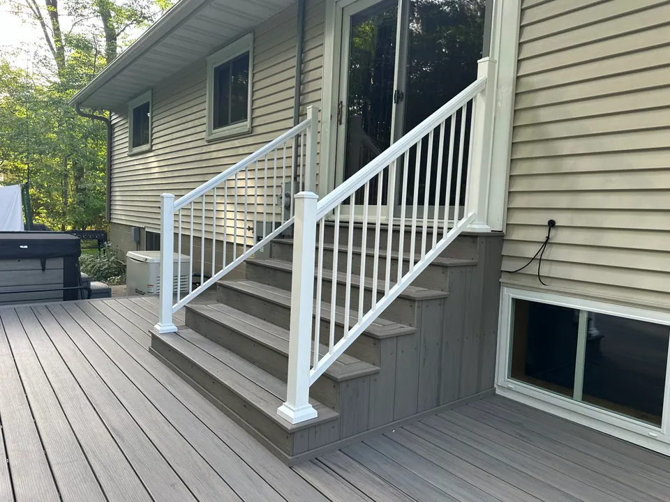 Grey composite deck with white vinyl stair railing
